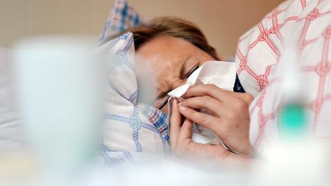 Mann mit Erkältung im Bett